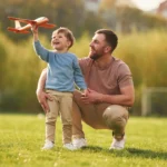 Dad with minimum essential coverage plays with his son outside.