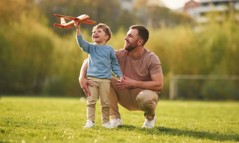 Dad with minimum essential coverage plays with his son outside.